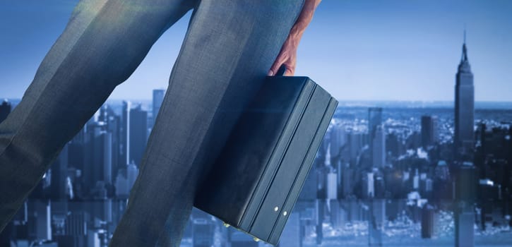 Businessman holding briefcase against mirror image of city skyline