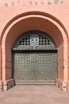 Old metal reinforced big double door in wide brick fortress wall