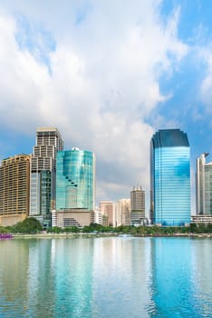 Modern city skyline of business district downtown with reflection in lake water in day under blue sky