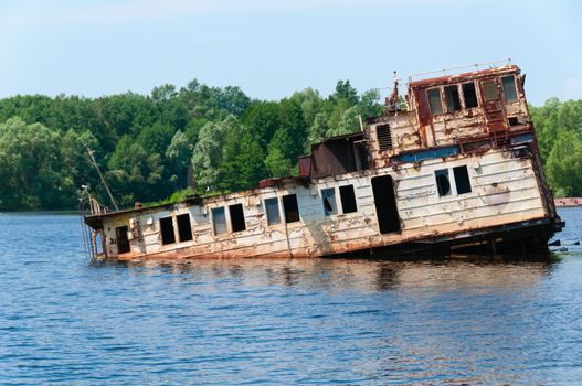 Wrecked abandoned ship on a river after nuclear disaster in Chernobyl, Ukraine