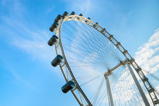 Big ferris wheel with cabins on blue sky