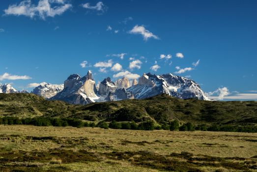 Panoramic view of snowy peaks and grassy meadows in Torres del Paine National Park
