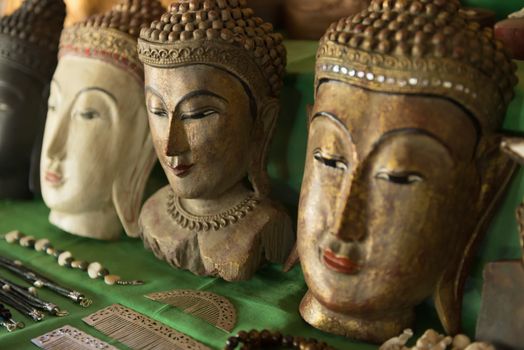 Buddha heads on a shop shelf as a Burmese souvenir. Selective focus on the second head.