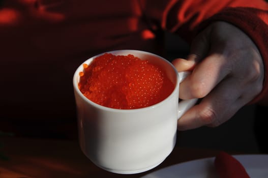A white cup full of red caviar