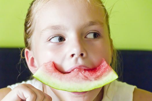 Photo of the cute girl eating watermelon