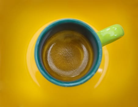 Picture of the top of a cup of coffee with yellow background