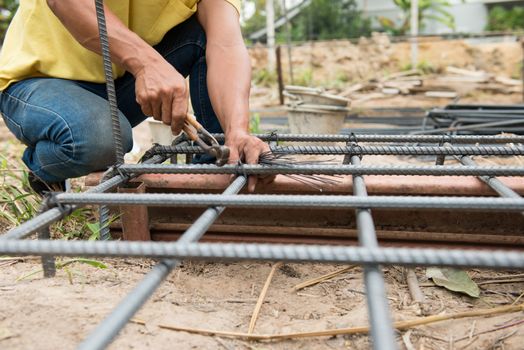 the workers are  preparing steel poles for building house