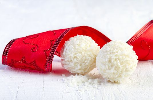 Coconut snowball truffles on white background. Arrangement of coconut cookies on wooden elegant background.