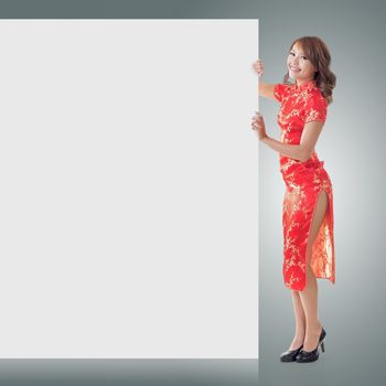 Attractive Chinese woman dress traditional cheongsam and hold blank board, full length portrait.