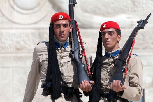 ATHENS, GREECE - JULY 23: Evzones (presidential guards) watches over the monument of the Unknown Soldier in front of the Greek Parliament Building at Syntagma Square on July 23, 2010 in Athens, Greece. Evzoni, is the name of historical elite mountain units of Greek Army.