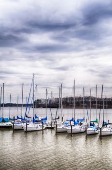 parked yachts in harbour with cloudy skies