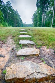 stone step stair leads to an open golf course