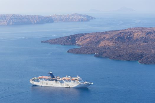 Luxury cruise ship sailing around Santorini island, Aegean sea in Greece.