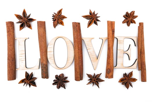 Star anise with cinnamon sticks isolated on white. Wooden letters forming the word LOVE