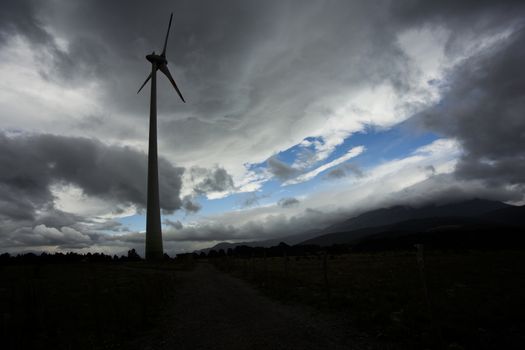 Wind turbine silhuette, with dark landscape background.
