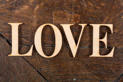 Wooden letters forming word LOVE written on old vintage wooden plates with space for your own text.