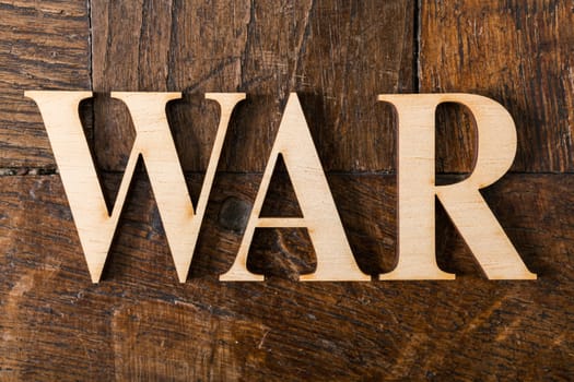 Wooden letters forming word WAR written on old vintage wooden plates