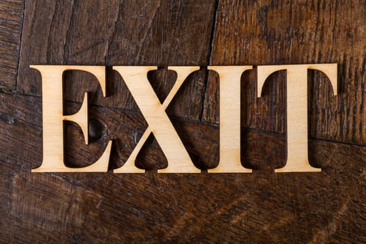 Wooden letters forming word EXIT written on old vintage wooden plates