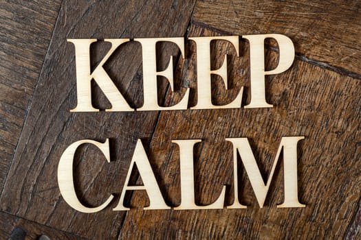 Wooden letters forming words KEEP CALM written on old vintage wooden plates