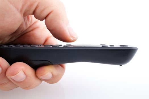 Hand holding TV remote control on white background