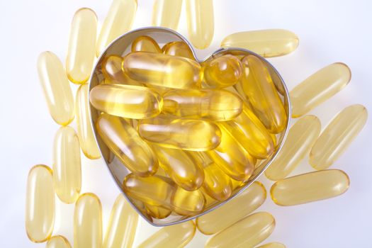 Vitamin capsules arranged in the shape of a heart to portray the concept of a healthy heart and lifestyle