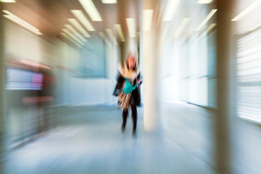 Intentional motion blurred image of a business people group walking in office lobby. All exposed faces are motion blurred.