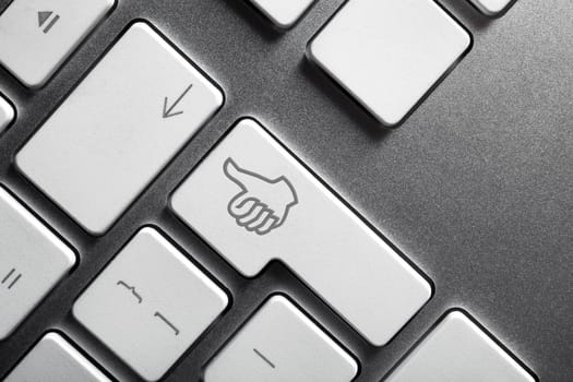 Close up of a keyboard with a gesturing hand featuring on Enter key