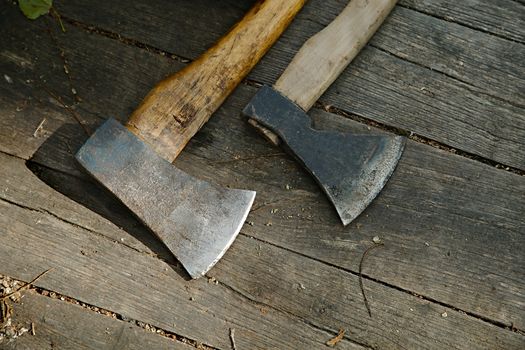 Two axes on a wooden surface