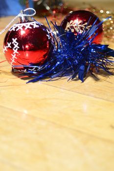 red christmas balls, blue garland, on a wooden floor