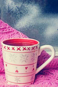 cup of tea on a windowsill near the winter window