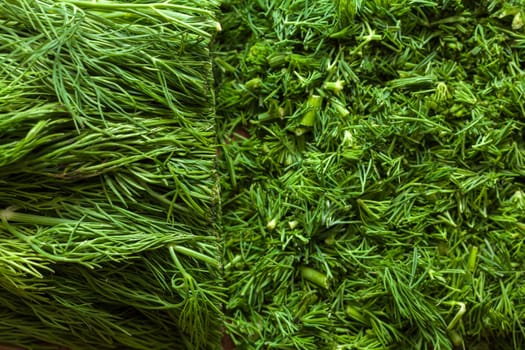 Fresh dill sprigs on wooden board cutting with knife