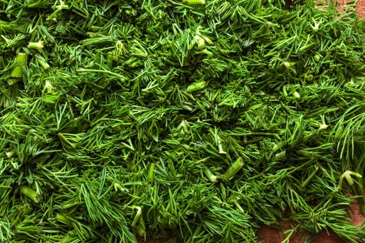 Fresh dill sprigs on wooden board cutting with knife