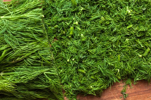 Fresh dill sprigs on wooden board cutting with knife