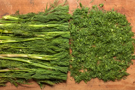 Fresh dill sprigs on wooden board cutting with knife