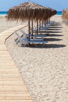 Beautiful beach with deck chairs and umbrellas on the sandy beach in Nea Irakleia (Halkidiki). Thessaloniki - Greece