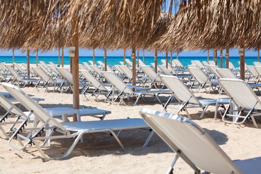 Beautiful beach with deck chairs and umbrellas on the sandy beach in Nea Irakleia (Halkidiki). Thessaloniki - Greece