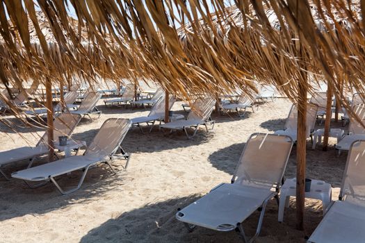 Beautiful beach with deck chairs and umbrellas on the sandy beach in Nea Irakleia (Halkidiki). Thessaloniki - Greece