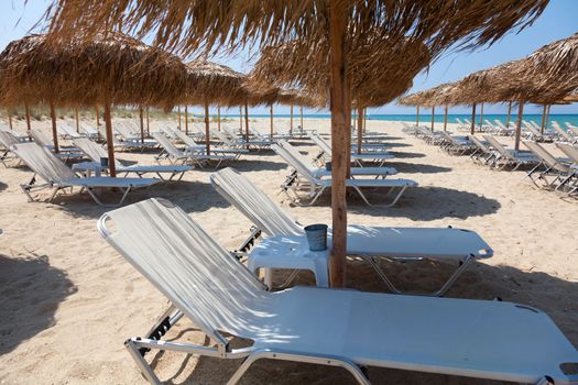 Beautiful beach with deck chairs and umbrellas on the sandy beach in Nea Irakleia (Halkidiki). Thessaloniki - Greece