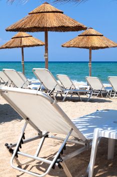 Beautiful beach with deck chairs and umbrellas on the sandy beach in Nea Irakleia (Halkidiki). Thessaloniki - Greece