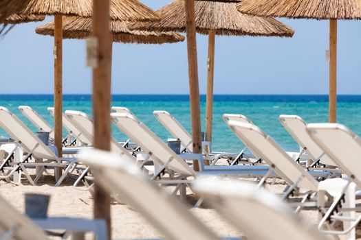 Beautiful beach with deck chairs and umbrellas on the sandy beach in Nea Irakleia (Halkidiki). Thessaloniki - Greece