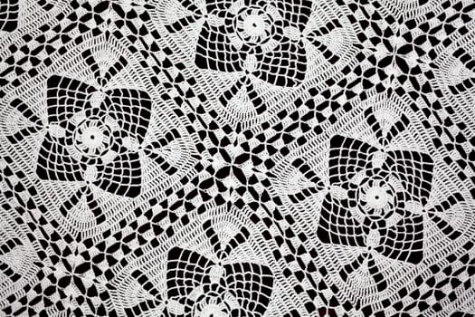 Handmade white lace doily runner on a black background