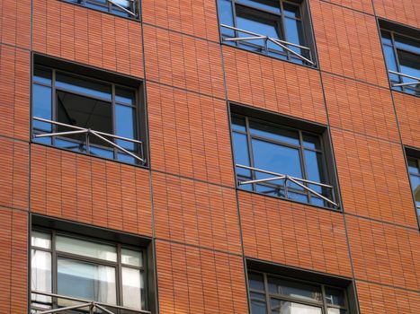 Building facade with red brick, arranged in square shapes.