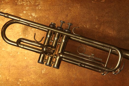 Brass trumpet horn on a golden background. Soft light photograph.