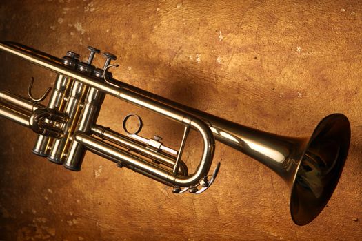 Brass trumpet horn on a golden background. Soft light photograph.