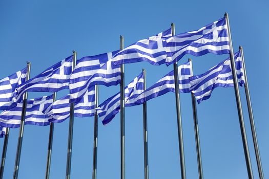 National Greek flags waving in wind against clear blue sky