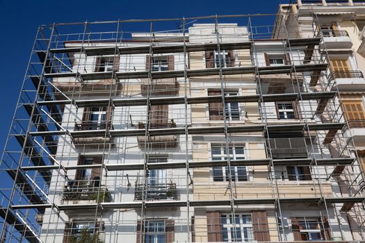 Old building under renovation. Scaffolding placed around the facades