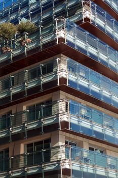 Modern building glass panel facades against the blue sky.