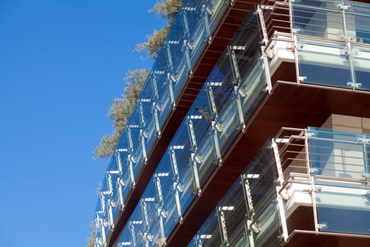 Modern building glass panel facades against the blue sky.