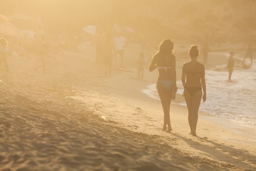 IKARIA ISLAND, GREECE - SEPTEMBER 14: Shapely silhouettes of girls who walk on the beach ''Armenistis'' in Ikaria Island on September 14, 2011 in Ikaria island, Greece.