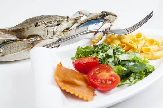 Blue crab on white background ready to eat a meal